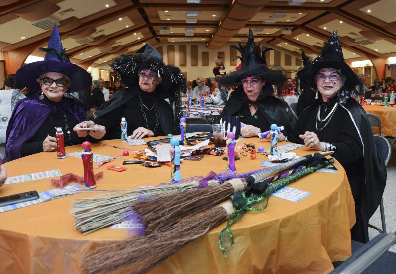 A coven of witches rest their brooms on the table. Shown are (l-r) Martha Stewart, Marilyn Coolbaugh, Dianne East and Dee Richards.